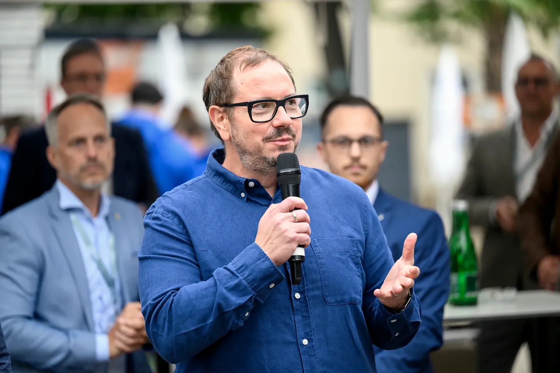 Editorial portrait of Armin Rogl with a microphone