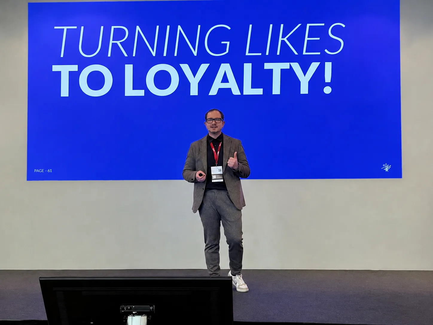 Armin Rogl on stage in front of a screen reading “to loyalty!”